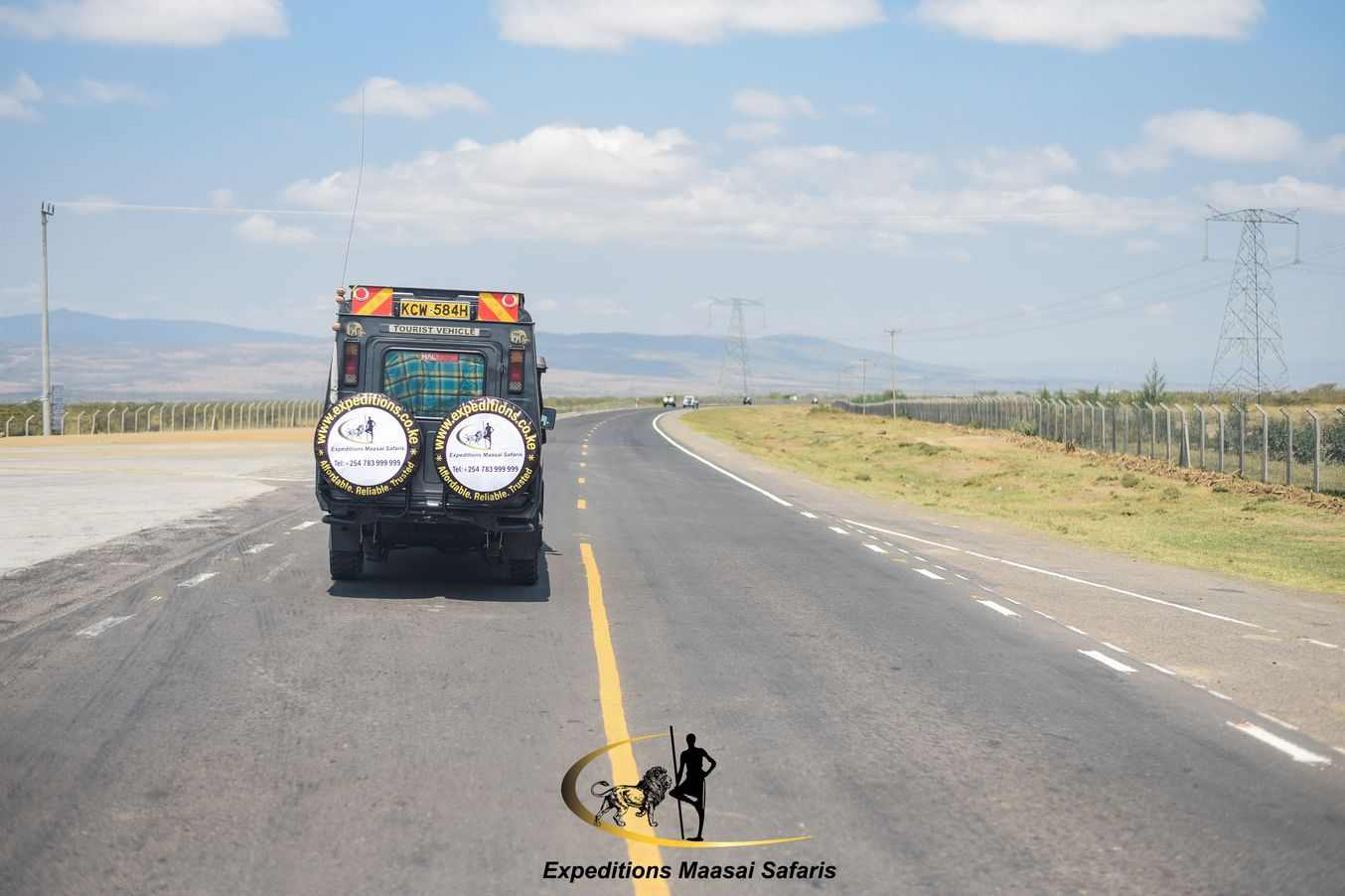 People on a safari in a tourist vehicle, a land cruiser, watching an elephant matriarch in Maasai Mara National Reserve